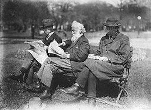 three men sit on a park bench reading newspapers and books historical black and white photo
