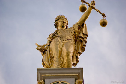 golden lady of justice statue holding the scales of justice